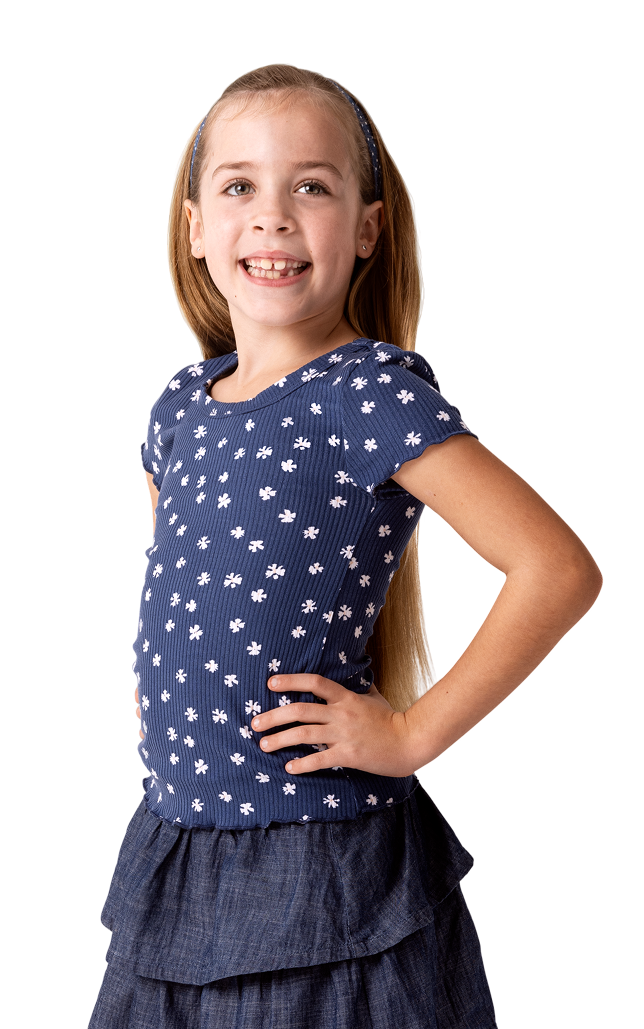 Cora, a person living with XLH, standing and smiling with her hand on her hip